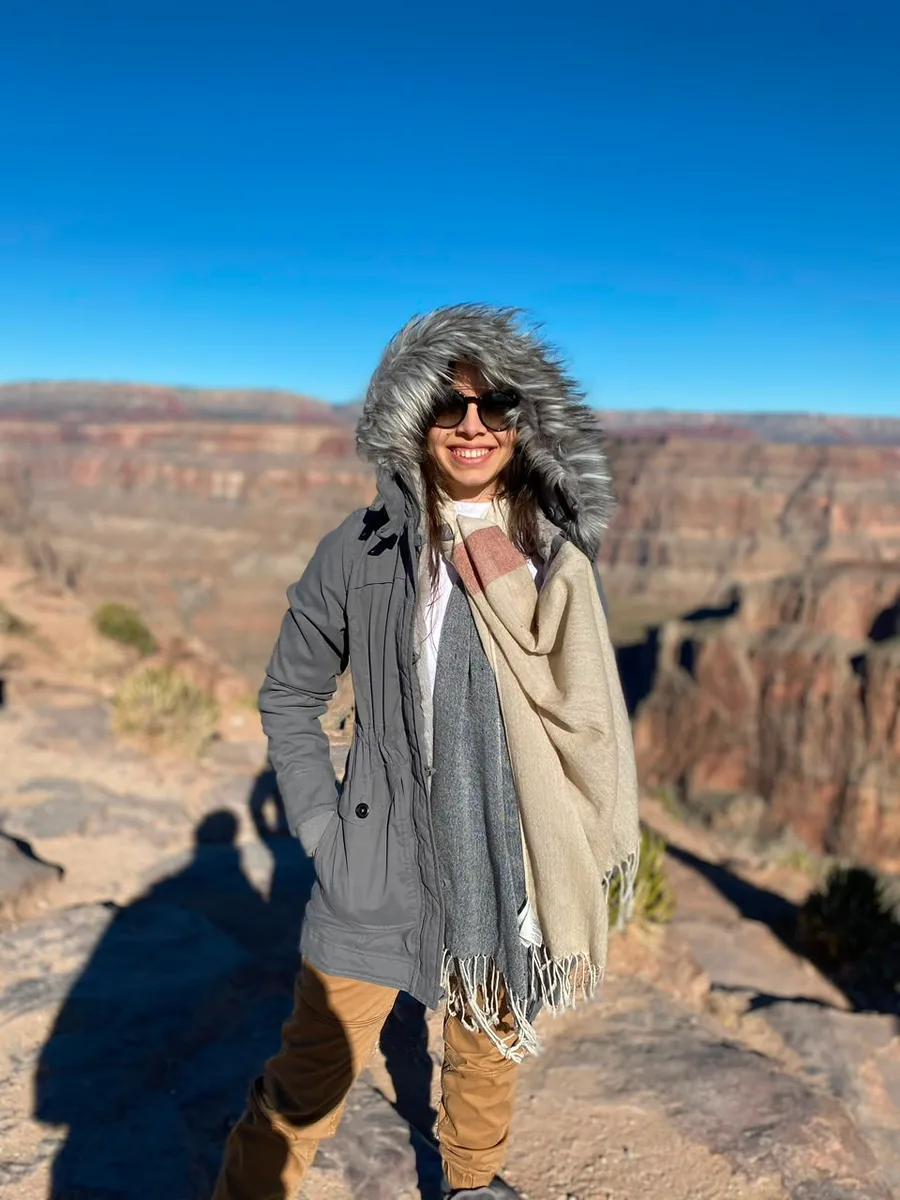 Julia com casaco de frio à beira de um cânion