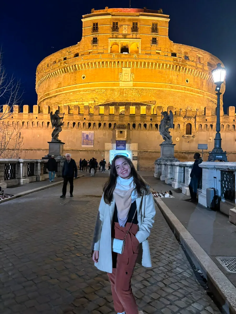 Julia à noite em frente ao Castelo de Sant'Angelo iluminado, em Roma